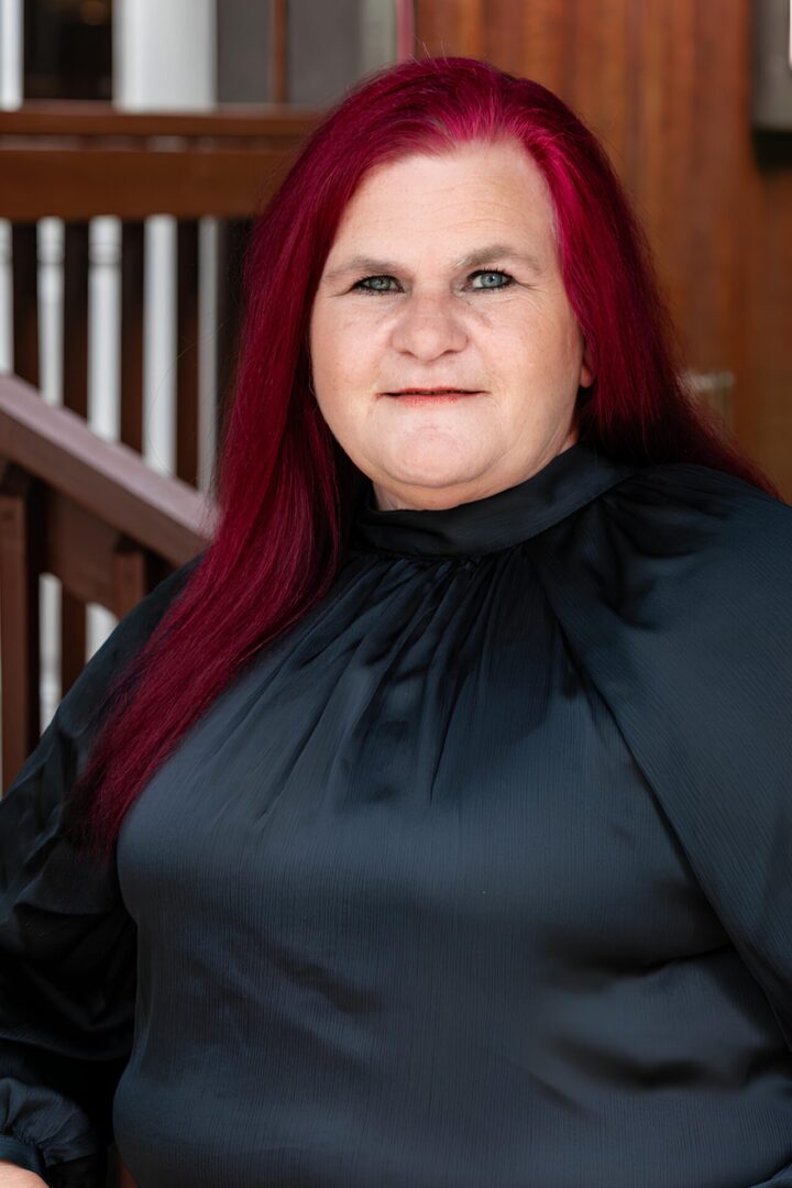 A woman with red hair and black shirt.